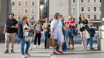 Group of tourists with guide in a city.