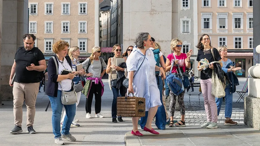Group of tourists with guide in a city.