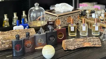 Parfümflaschen auf einem Holztisch arrangiert.