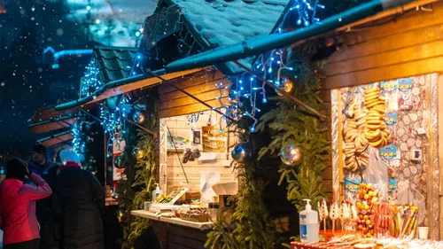 Christmas market stalls decorated with lights.