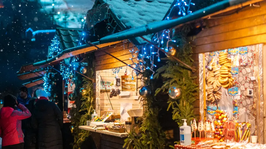 Christmas market stalls decorated with lights.