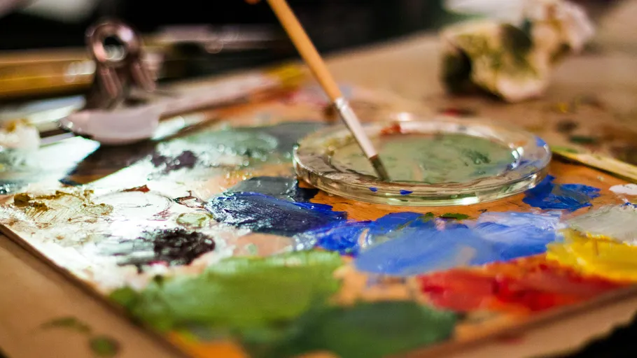 Pinsel mischt Farben auf Künstlerepalette.