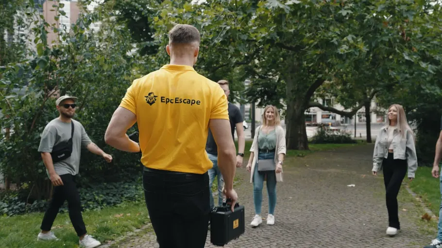 Man in yellow shirt leading group outdoors.