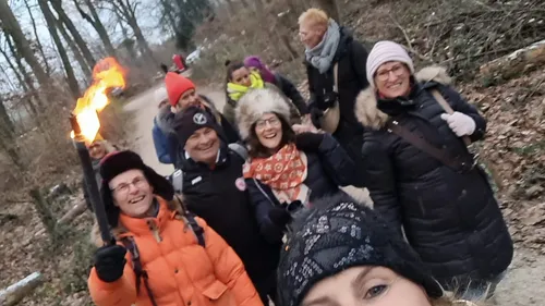 Gruppe wandert auf einem Waldweg.