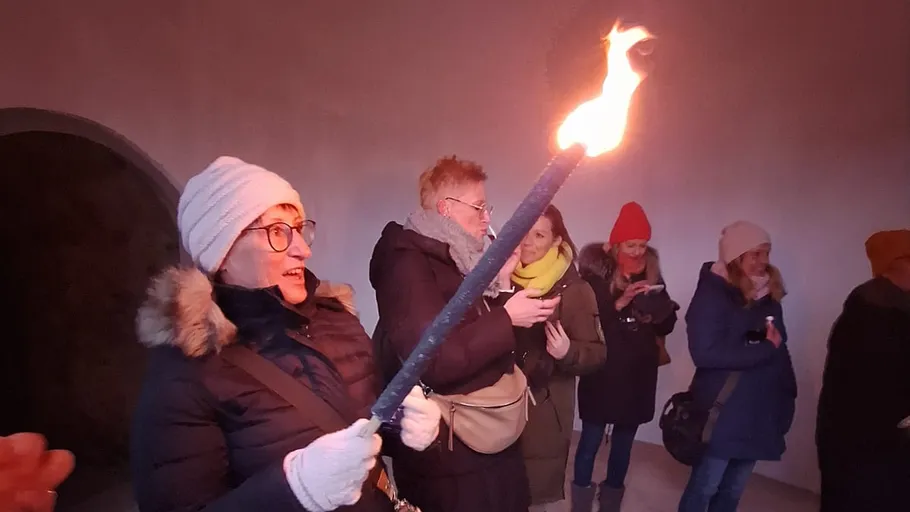 Personen halten eine brennende Fackel drinnen.