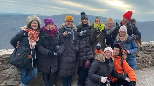 Gruppe von Frauen posiert auf einer Terrasse draußen.