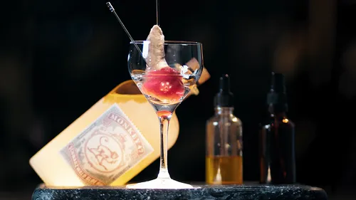 Glas mit ungewöhnlicher Garnierung auf Bartheke.