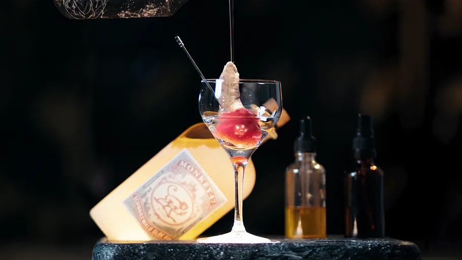 Glass with unusual drink garnish on bar counter.