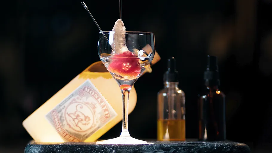 Glass with unusual drink garnish on bar counter.