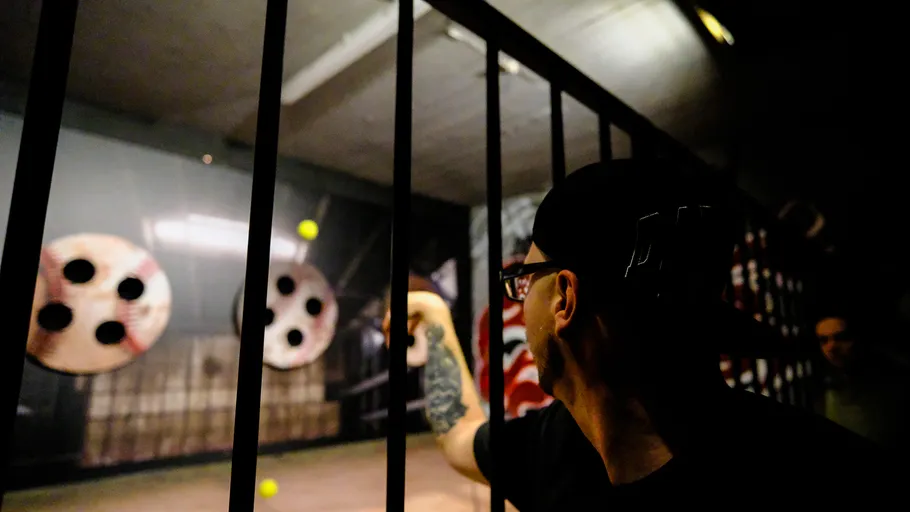 Person throwing ball at targets indoors.