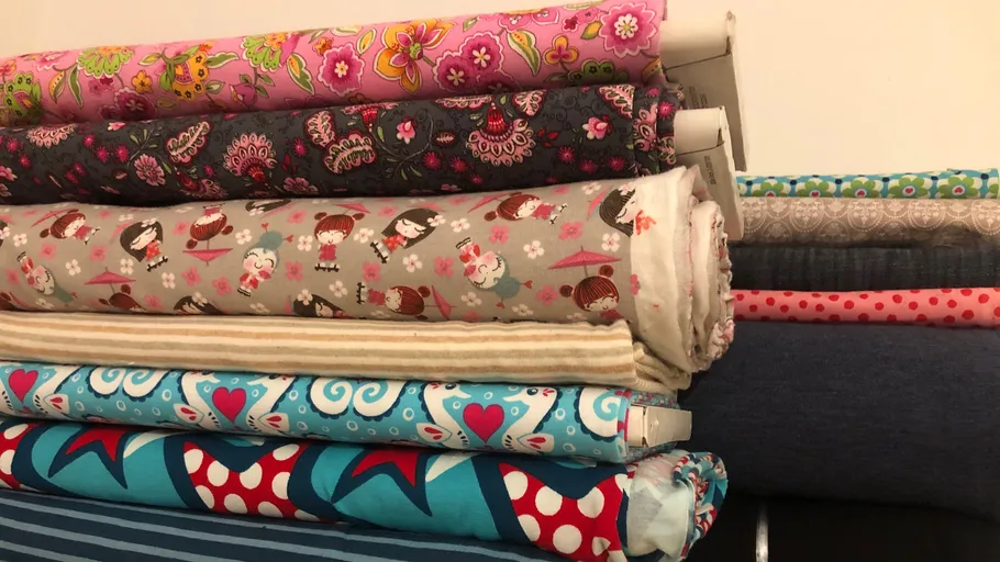 Stack of colorful fabric rolls on display.