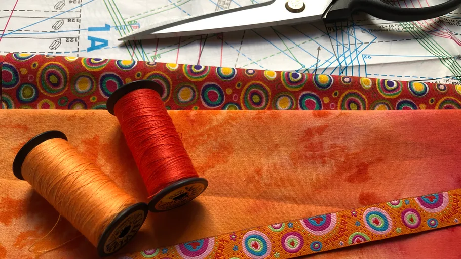 Colorful fabric with sewing threads and scissors.