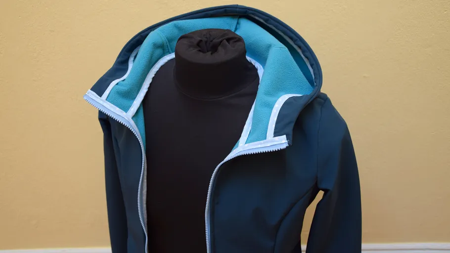 Jacket on mannequin, open hood, indoor background.