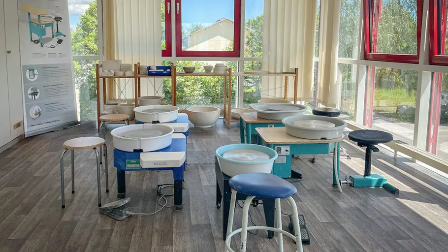 Pottery wheels arranged in a bright studio.