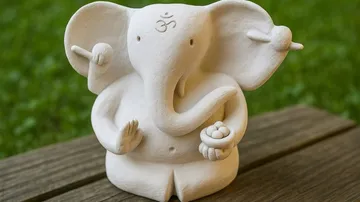 Elefantenstatue auf Holzoberfläche im Freien sitzend.