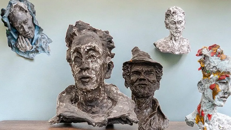 Clay busts displayed on a shelf.