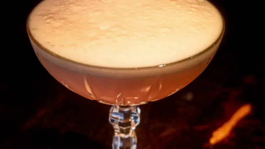 Schaumiger Cocktail in einem Stielglas.