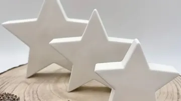 Drei weiße Sterne auf Holzoberfläche.