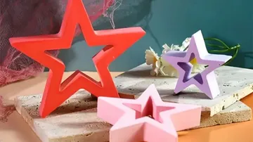Bunte sternförmige Objekte auf Stein und Holz.