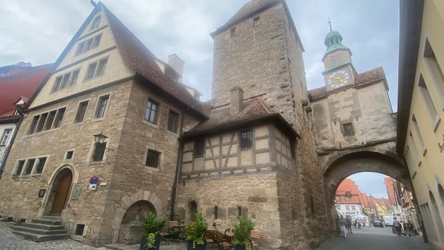 Mittelalterliches Steingebäude mit Torbogen, Kopfsteinpflasterstraße.
