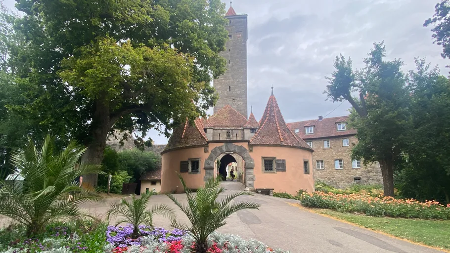 Historisches Torhaus mit Turm und Bäumen.
