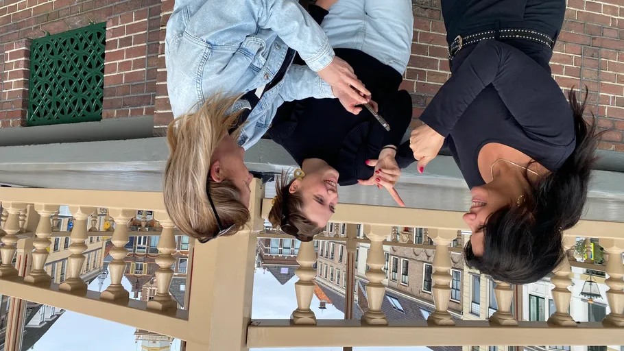 Three women talking on a bridge.