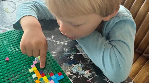 Child assembling colorful blocks on a board.