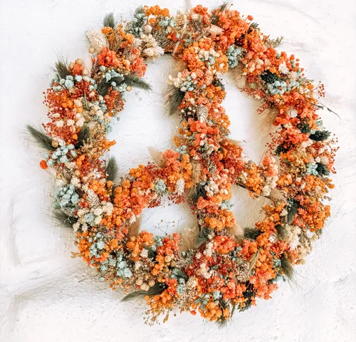 Floral peace sign on white wall.