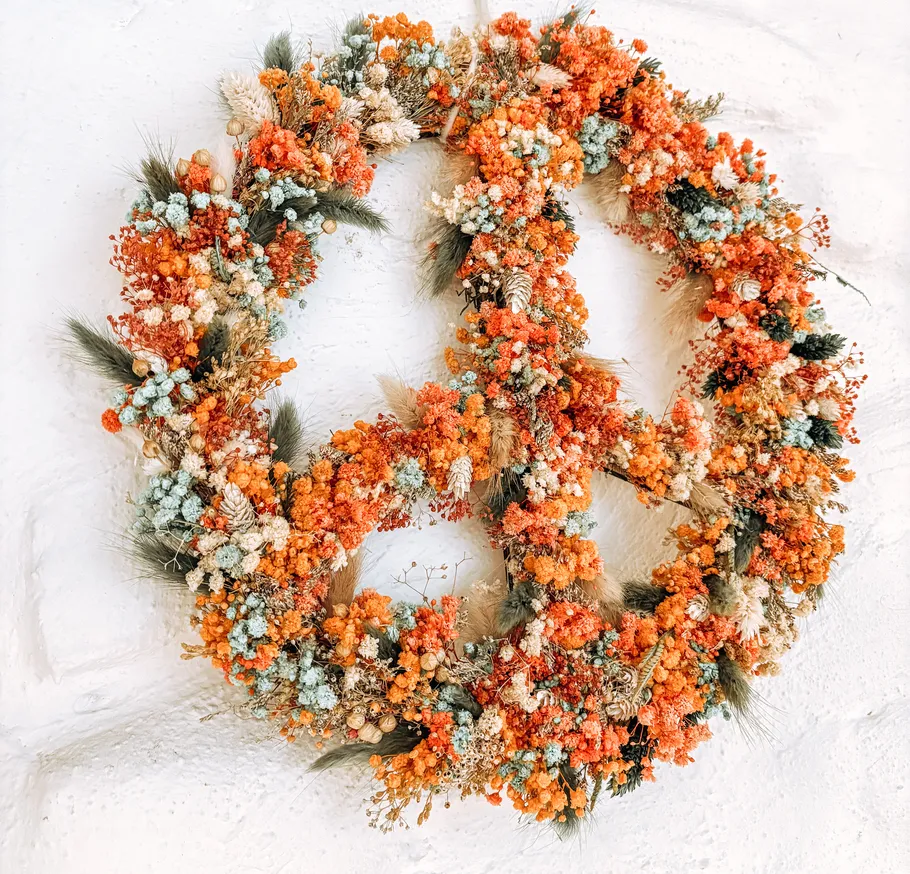 Floral peace sign on white wall.