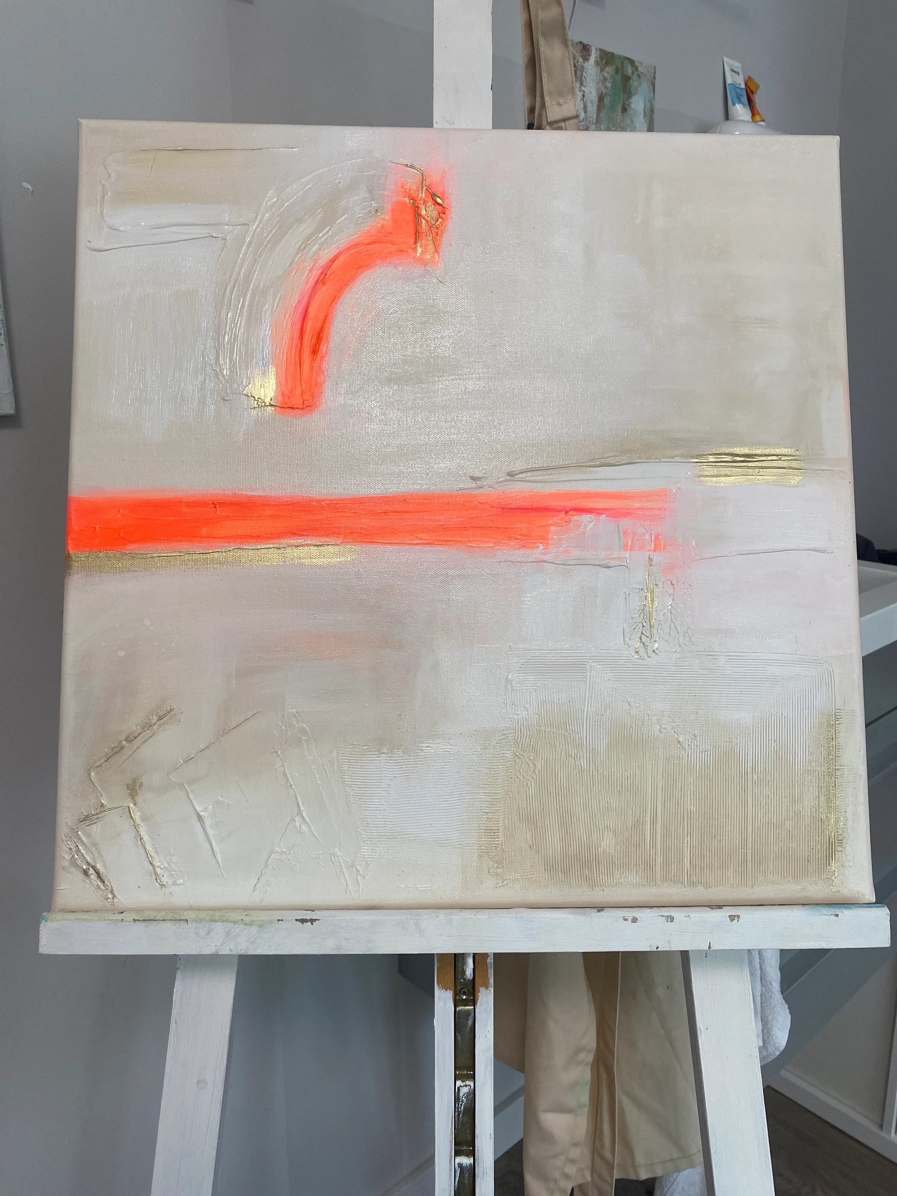 Abstraktes Gemälde mit Neonakzenten auf Staffelei.