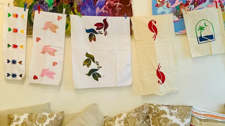 Bunte bedruckte Stoffe hängen an einer Wand.