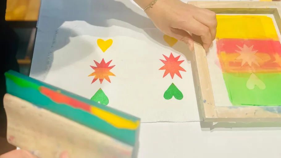 Person uses squeegee for screen printing.