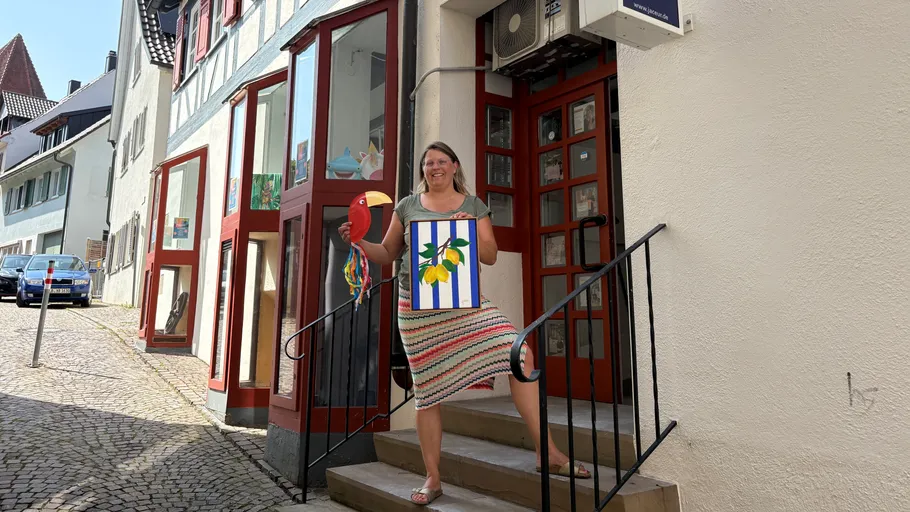 Lächelnde Frau mit bunter Kunst auf Treppe.