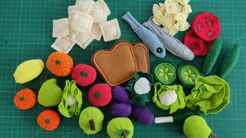 Fabric toys of food on a green mat.