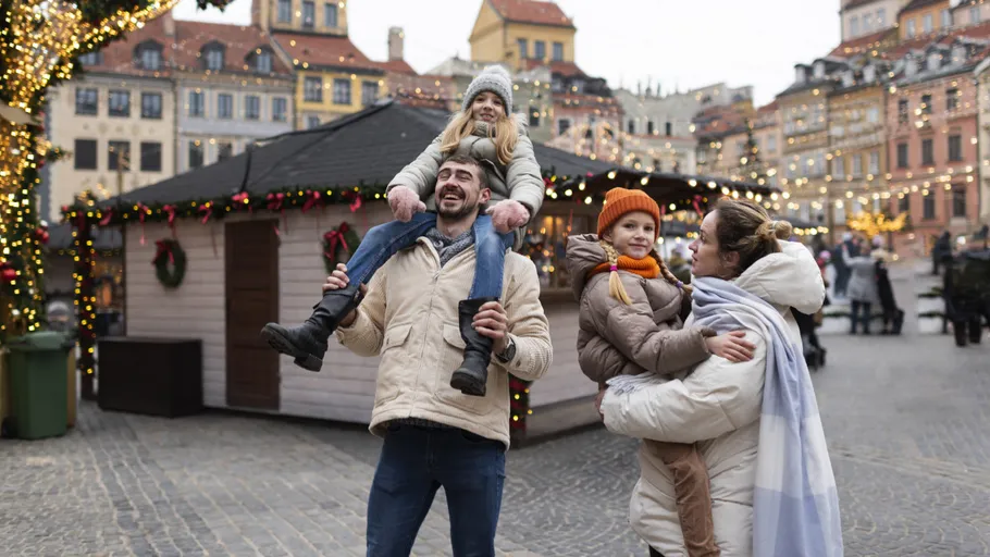 Family enjoying Christmas market with lights.