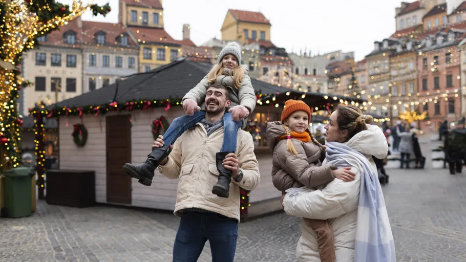 Family posing in festive decorated town square.