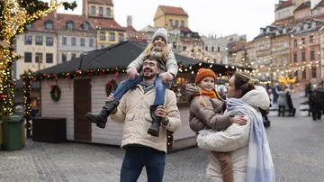 Familie genießt Weihnachtsmarkt mit festlichen Lichtern.