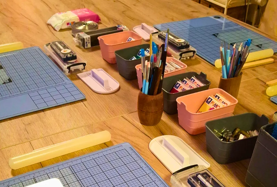 Bastelmaterialien organisiert auf Holztisch.