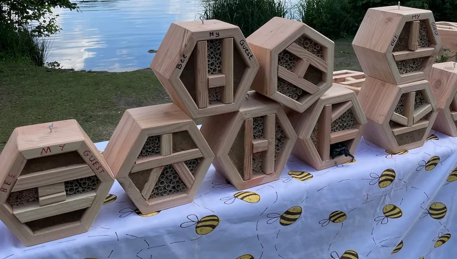 Bee hotels on a table by a lake.