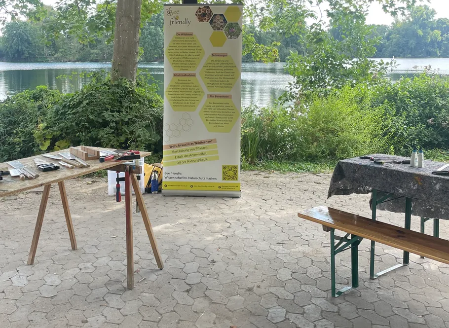 Outdoor workshop setup near a lake with banner.