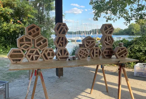 Hexagonale Bienenhotels auf einem Tisch im Freien.
