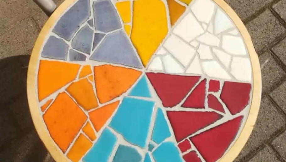 Bunter Mosaiktisch in Außenumgebung.