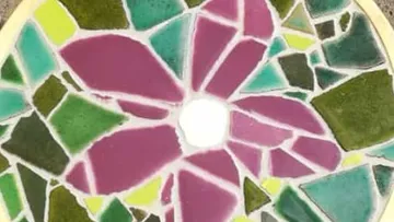 Colorful mosaic flower on round surface.