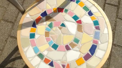 Colorful mosaic table on pavement.