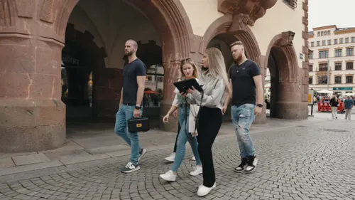 Vier Personen gehen im historischen Stadtzentrum.