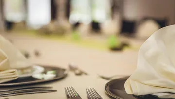 Elegantly set dining table with plates.