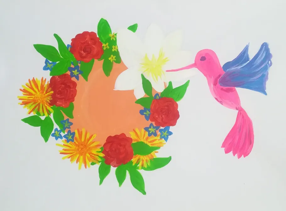 Kolibri nahe kreisförmiger Blumenanordnung.