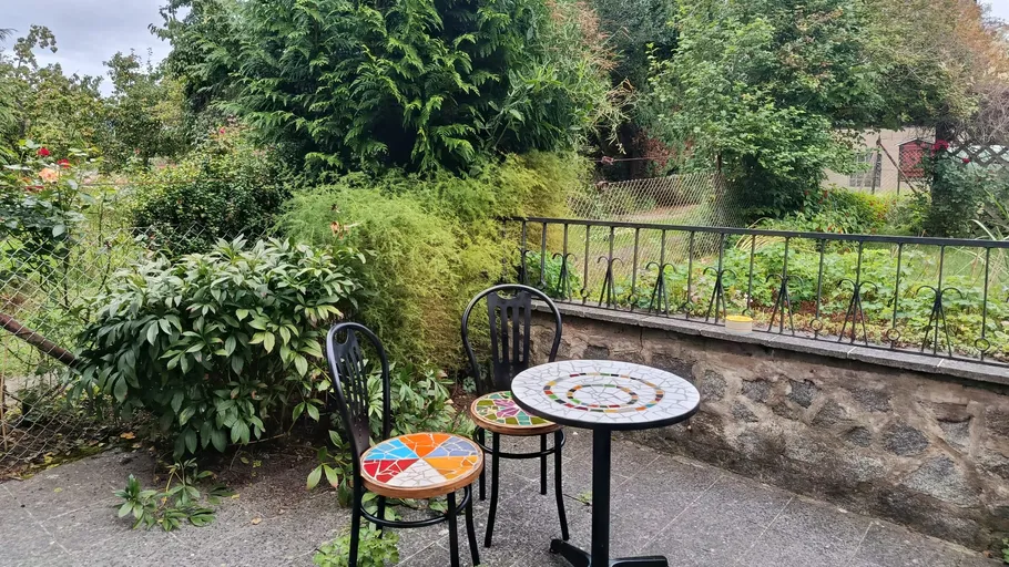 Two chairs and table in garden patio.
