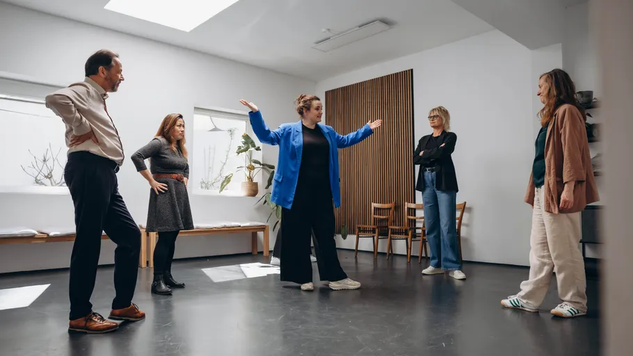 Gruppe von Menschen spricht in hellem Raum.