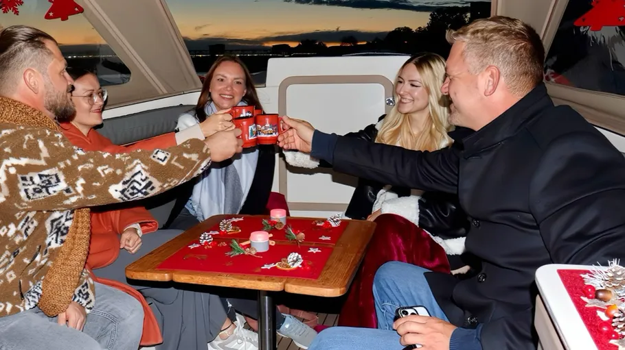 Group toasting with mugs inside festive boat.